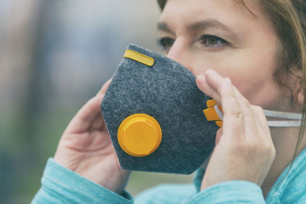 Kobieta zakładająca maskę antysmogową